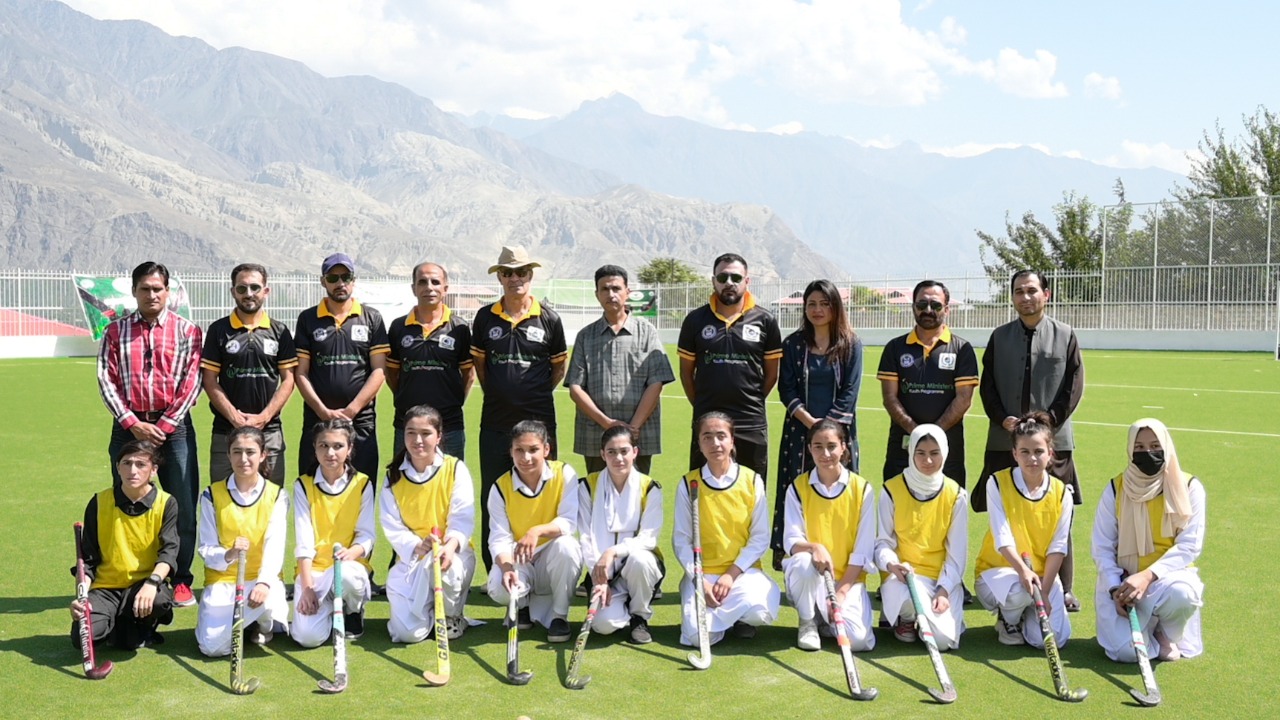 A group photo of Former Captain of Pakistan Hockey Team Rehan Butt with women in hockey trials under Prime Minister Talent Hunt Sports League held in Gilgit Baltistan.